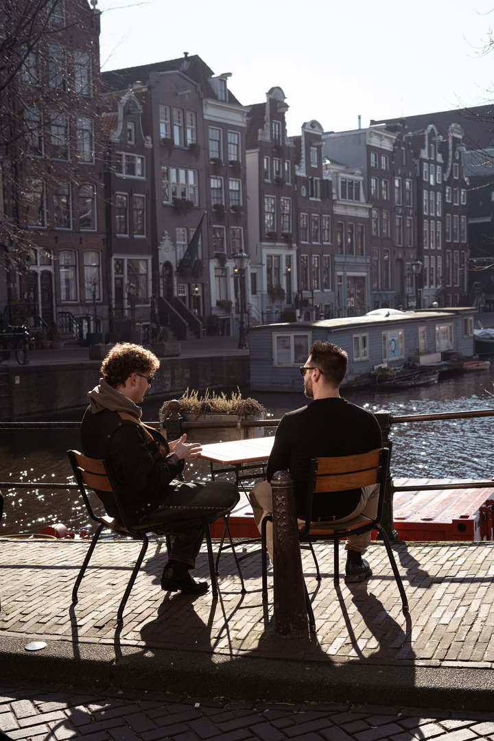 Two members in conversation along an Amsterdam canal